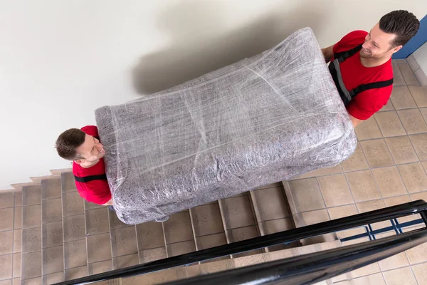 Dua Pemuda Pengiriman Pria Berseragam Melepas Pembungkus Sofa Pindah Bawah — Stok Foto