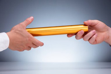 Gri Arkaplan Karşısında Altın Bayrak Bayrağını İşadamına Veren Bir Elin Yakın Çekimi
