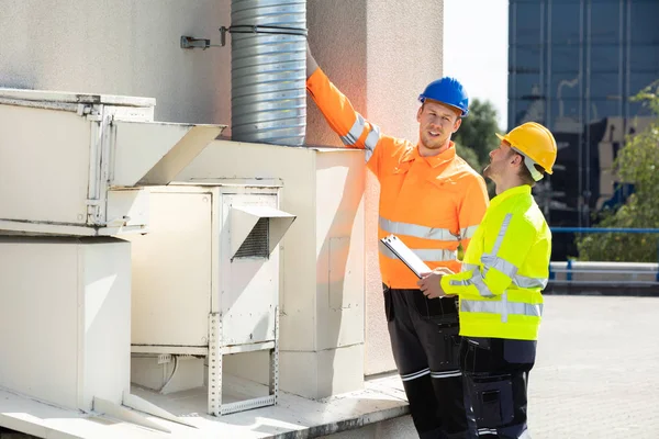 Twee Elektriciens Mannen Dragen Veiligheidsjassen Controleren Van Airconditioning Het Dak — Stockfoto