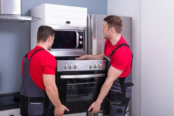 Side View Two Young Male Worker Placing Modern Oven Cabinet — Stock Photo, Image