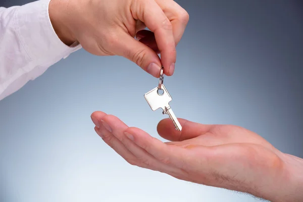 Close Real Estate Agent Hand Giving Keys Property Owner Gray — Stock Photo, Image