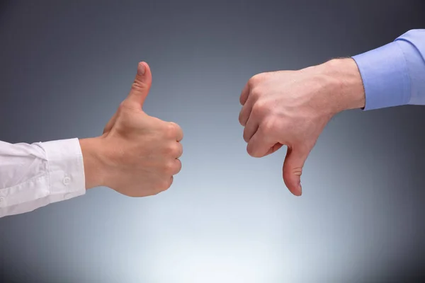 Close Two Businessman Hands Wyświetlanie Kciuki Górę Dół Znak Szarym — Zdjęcie stockowe