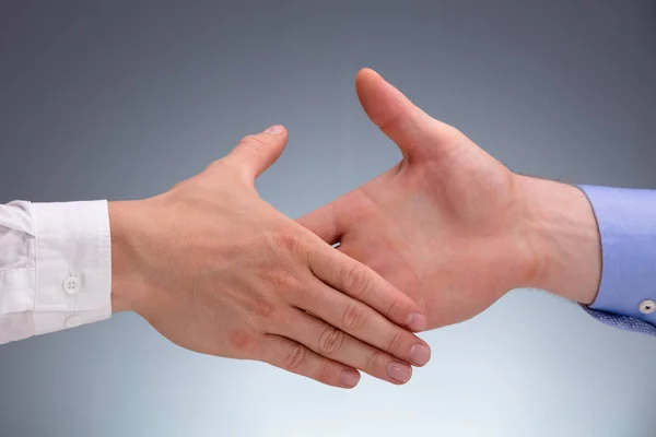 Nahaufnahme Zweier Geschäftsleute Beim Händeschütteln Vor Grauem Hintergrund — Stockfoto