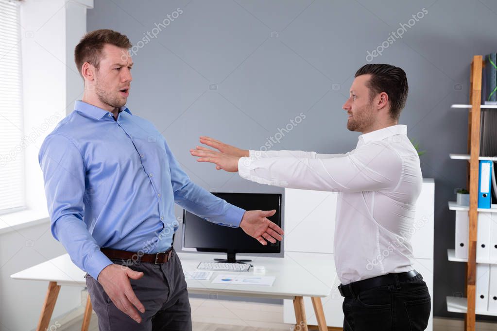 Two Angry Young Businessmen Quarreling With Each Other Fighting In The Office