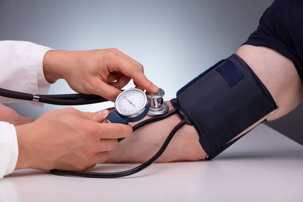 Close Doctor Checking Blood Pressure Male Patient Table Gray Background Royalty Free Stock Photos