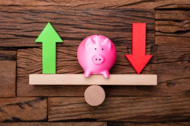 Yukarı ve aşağı oklar ve tahtadan masadaki tahterevalli kumbarası