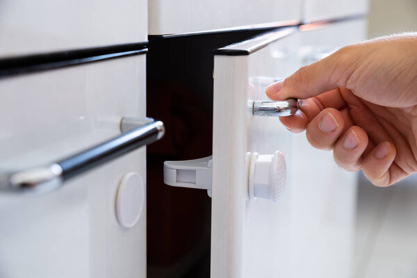 Close-up Photo Of Man Opening Child Proof Kitchen Cabinets