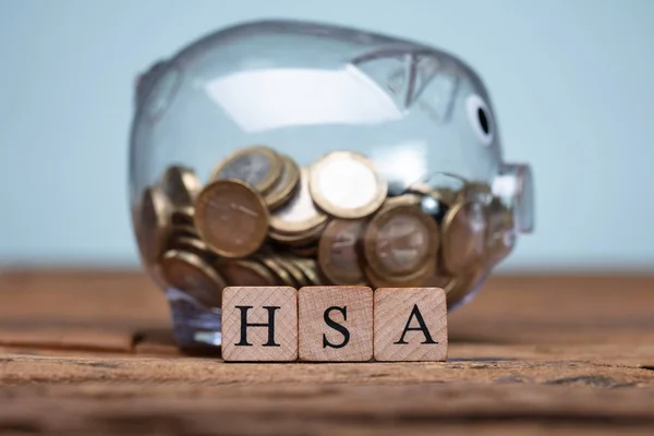 HSA Health Savings Account Wooden Blocks Near Piggybank On Table