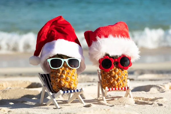 Nahaufnahme Von Zwei Ananas Mit Weihnachtsmützen Und Sonnenbrille Auf Einem — Stockfoto