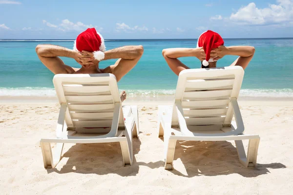 Rear View Couple Wearing Santa Hats Relaxing White Deck Chairs — Stock Photo, Image