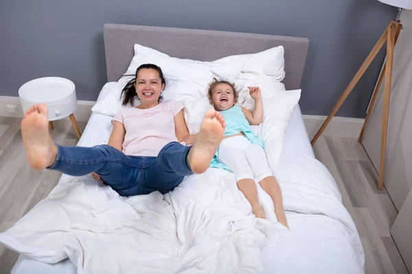 快乐的母亲与女儿同床共眠的俯视图 — 图库照片