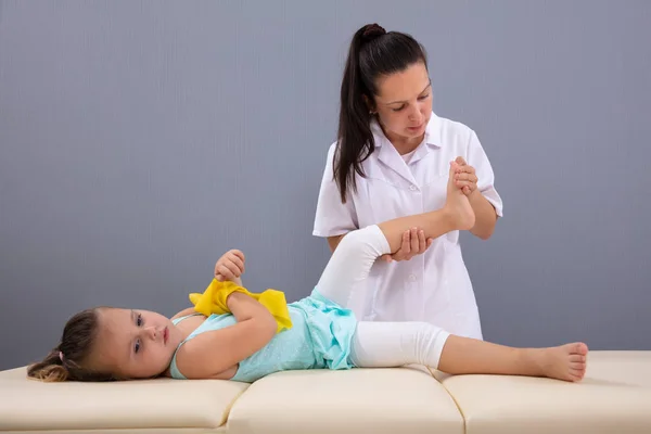 Fisioterapeuta Femenina Haciendo Masaje Pie Niña Clínica Médica Contra Pared — Foto de Stock