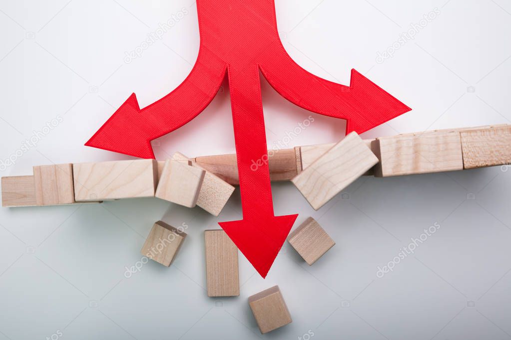 Arrow Breaking Through Wall Made Of Wooden Blocks On White Background