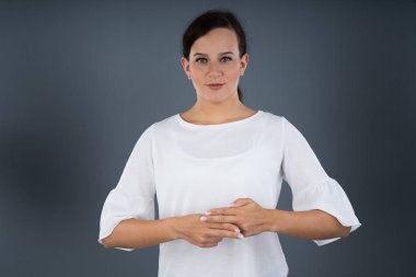 Gri Arkaplana Karşı İletişim kurmak için İşaret Dili Kullanan Kadın