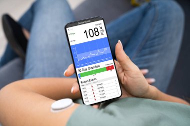 Ekranda kötü seviyede kan şekeri olan akıllı telefonu elinde tutan kadın.