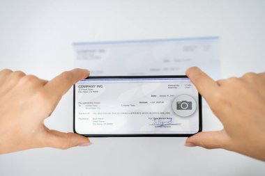 Banka hesabına uzaktan para yatırmak için çek çeken bir kadın.