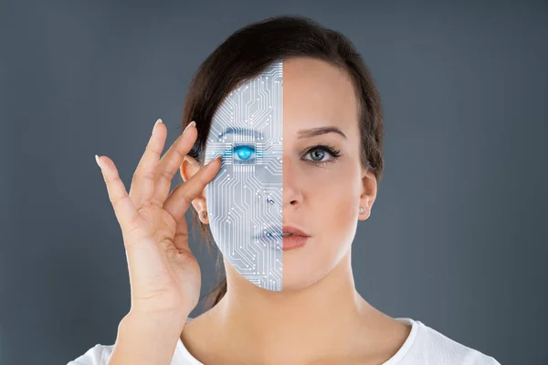Close-up Of Two Faces Showing Woman And Robot Against Grey Background