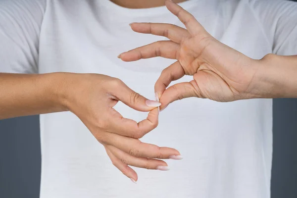Wanita Menggunakan Bahasa Isyarat Untuk Berkomunikasi Melawan Latar Belakang Abu — Stok Foto