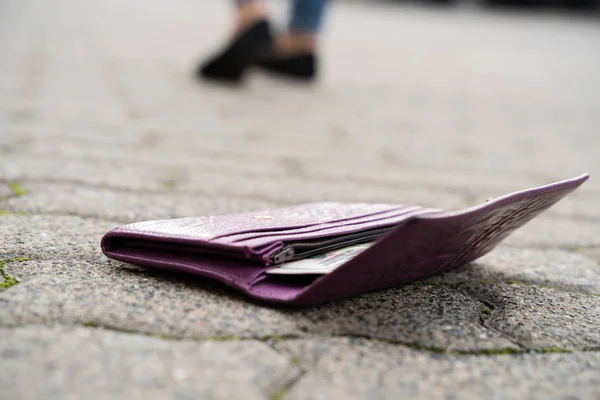 Mujer Caminando Contra Cartera Caída Calle —  Fotos de Stock