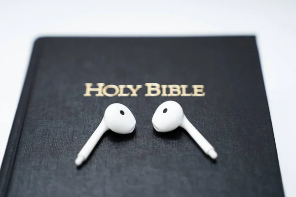 Φωτογραφία Των Λευκών Ασύρματων Ακουστικών Στο Βιβλίο Της Βίβλου — Φωτογραφία Αρχείου
