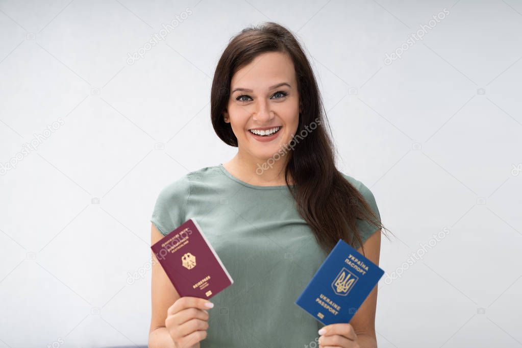 Happy Woman Holding Two Passports. Ukrainian And German