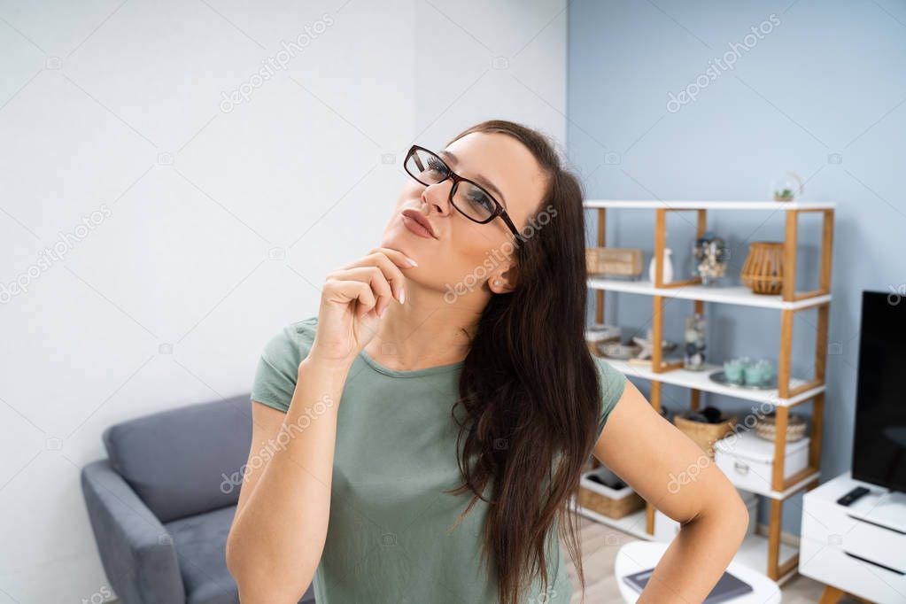 Portrait Of Thoughtful Young Woman In Living Room