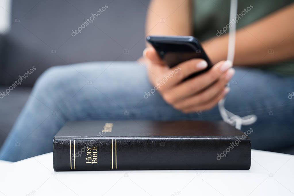 Woman Listening To Bible Audiobook On Smartphone