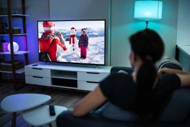 Kanepede ya da koltukta televizyon izleyen bir kadın. Televizyon İzle