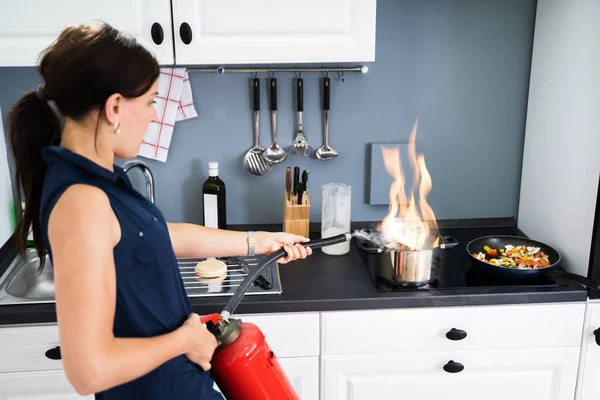 Woman Using Fire Extinguisher Stop Fire Burning Cooking Pot Kitchen — Stock Photo, Image