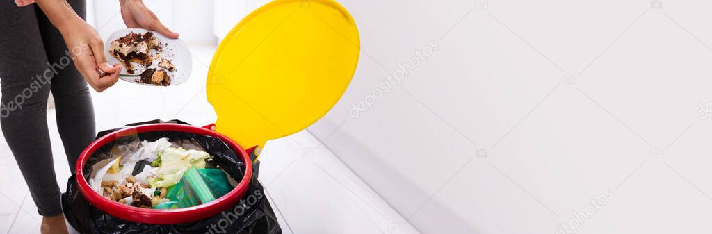 African Woman Throwing Trash In Kitchen Garbage Bin