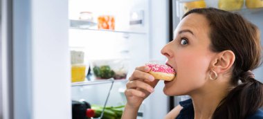 Donut Yiyen Aç Genç Kadın Buzdolabının Yanında