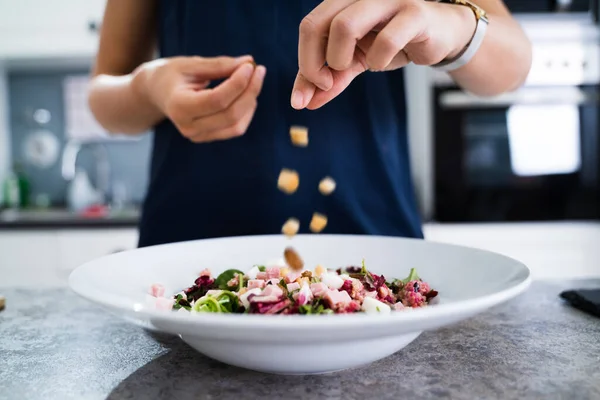 Vrouw Koken Salade Keuken Strooien Broodkruimels — Stockfoto