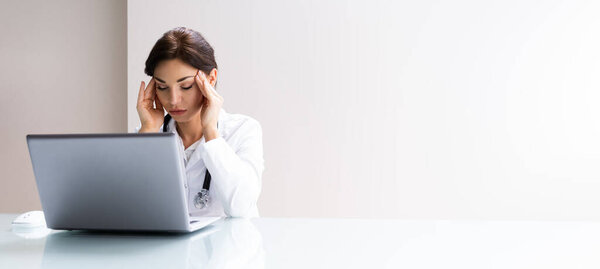 Sad Stressed Doctor Having Pain Using Computer