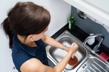 Mutfakta lavabo ve kanalizasyonu temizlemek için pompa kullanılıyor.