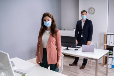 Ofisteki İş Çalışanları Tıbbi maske takıyor ve Sosyal Mesafe Protokollerini izliyorlar