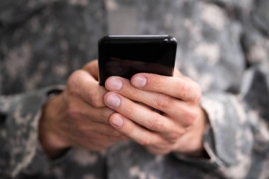 Social Cyber Warfare. Army Soldier Using Smart Phone clipart