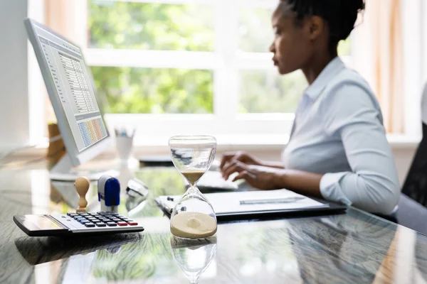 Black Accountant Woman Working With Invoice And Hourglass