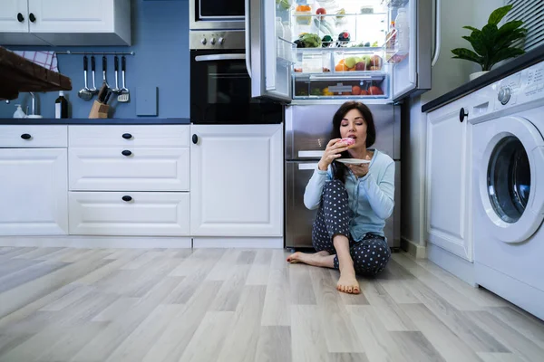 Noche Abierta Dulce Indulgencia Mujer Comiendo Cerca Del Refrigerador —  Fotos de Stock