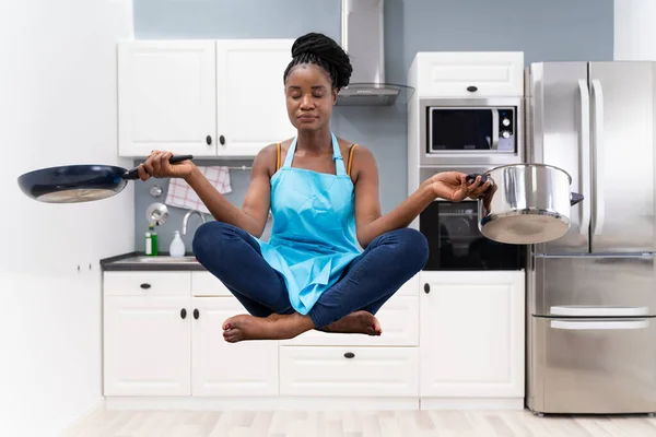 Stressed African Housewife Woman Meditating In Kitchen