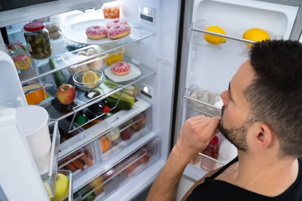 Πεινασμένος Μπερδεμένος Άνθρωπος Ψάχνει Ανοιχτό Ψυγείο Στην Κουζίνα — Φωτογραφία Αρχείου