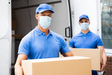 Mavi Nakliyeciler Yüzü Maskeli Kamyon 'dan Paket Boşaltıyorlar