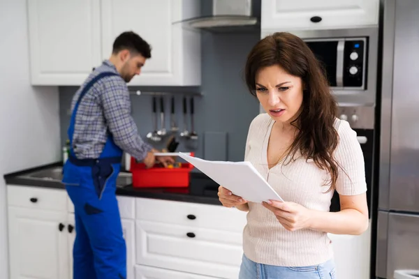 自宅で高価な修理請求書を持つ顧客女性 — ストック写真