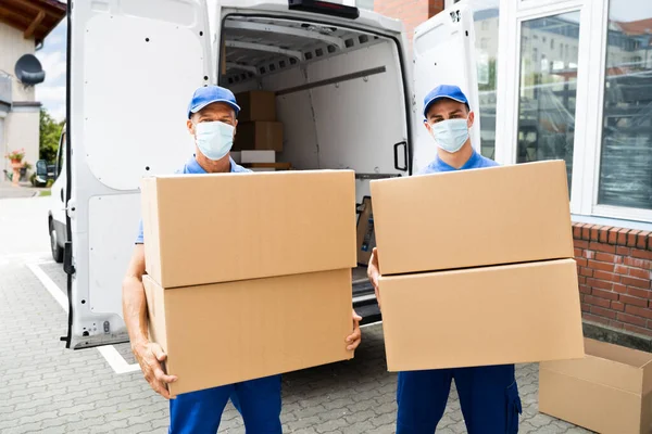 Blauwe Levering Mannen Lossen Pakket Van Vrachtwagen Met Gezicht Masker — Stockfoto