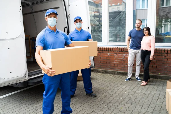 Blauwe Levering Mannen Lossen Pakket Van Vrachtwagen Met Gezicht Masker — Stockfoto