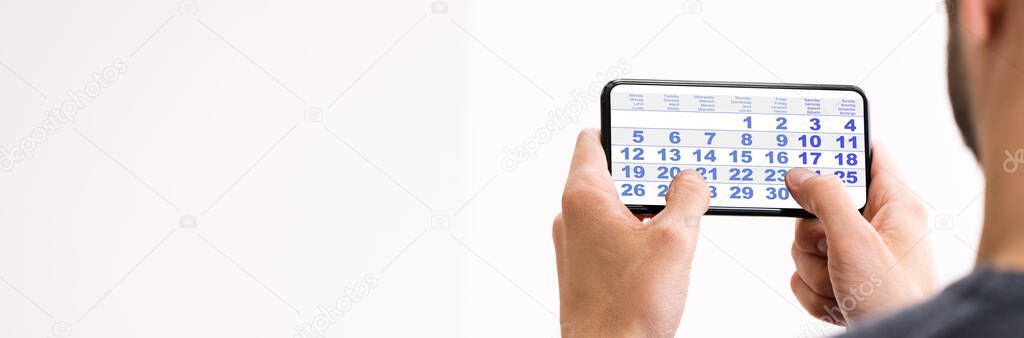 Male Looking At Calendar On Smart Phone