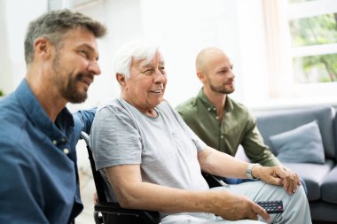 Aile, oturma odasında dedemle televizyon izliyor.