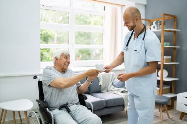 Yaşlı hasta bakım hemşiresi çay getiriyor.