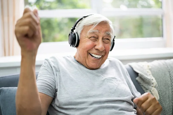 Lächelnder Älterer Senior Hört Musik Über Kopfhörer — Stockfoto