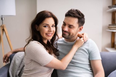 Mutlu bir adam ve kadın evdeki koltukta ya da koltukta oturuyordu.