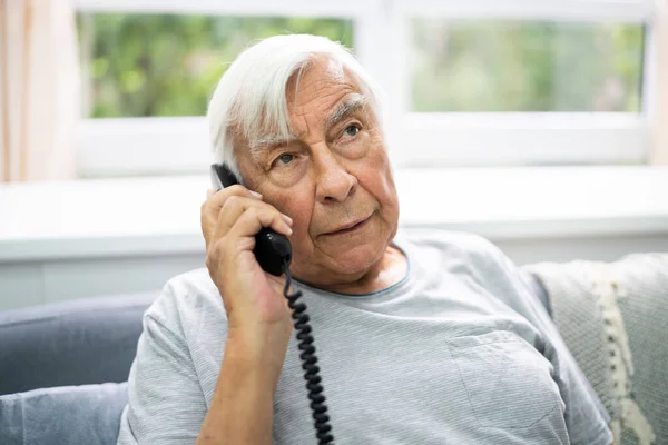 Starszy Starzec Rozmawiający Przez Telefon Stacjonarny — Zdjęcie stockowe
